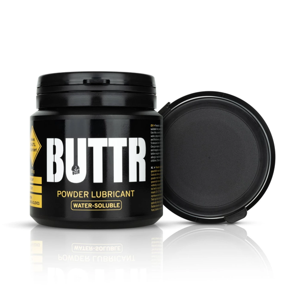 Product studio shot showing the black 135 g BUTTR Powder Lubricant tub standing next to its detached lid.