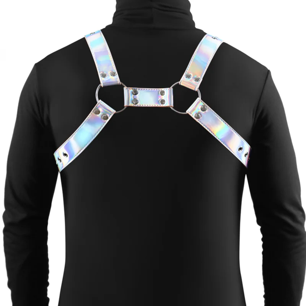 Rear studio view showing the back construction of the iridescent vinyl chest harness connected with metal studs and central metal rings.