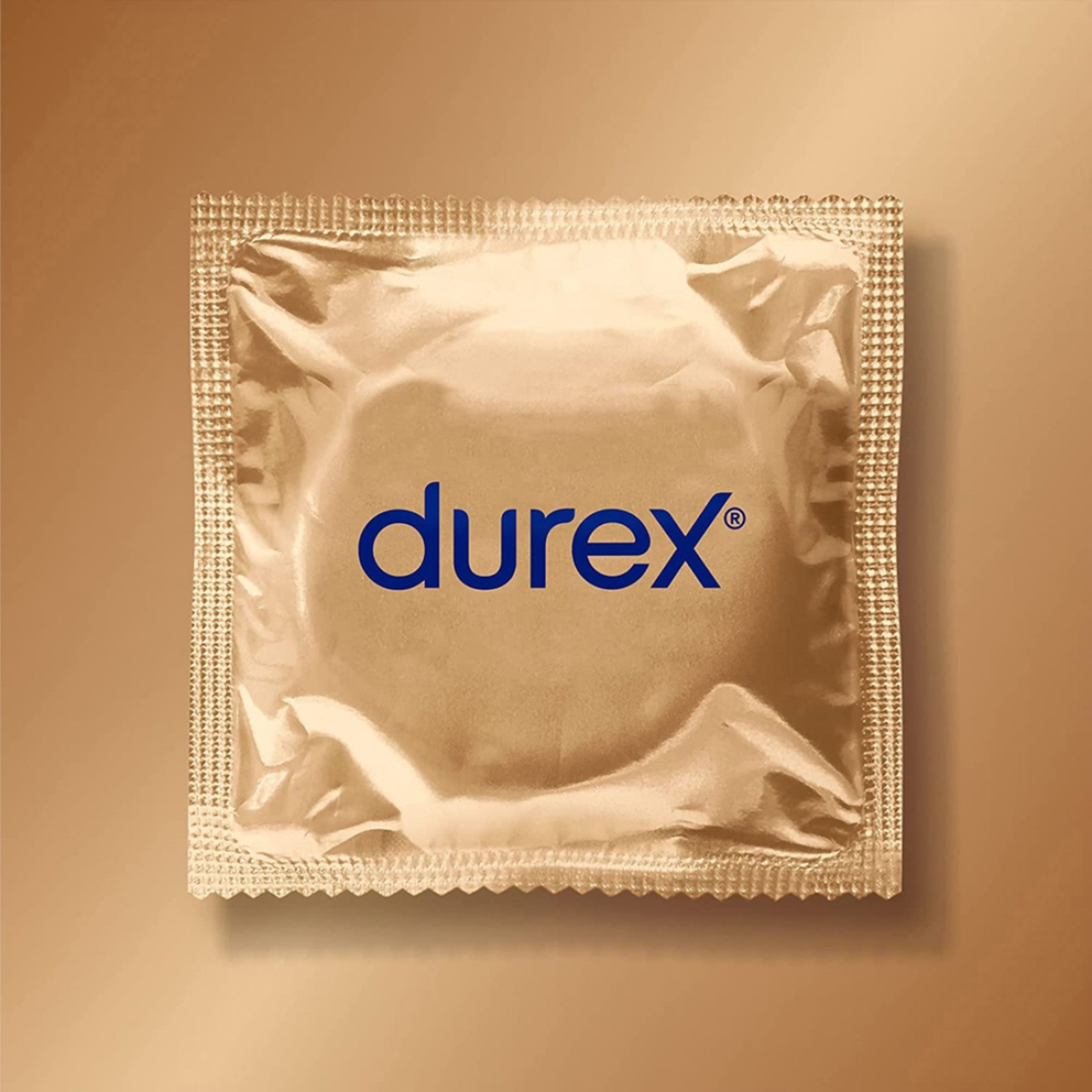 A top-down, centered shot of a single, square Durex Sensual XL condom wrapper. The wrapper is made of crinkled, metallic gold foil with serrated edges for easy opening. The blue Durex logo is printed horizontally across the center. The wrapper is set against a soft, gradient gold background that matches its metallic sheen.