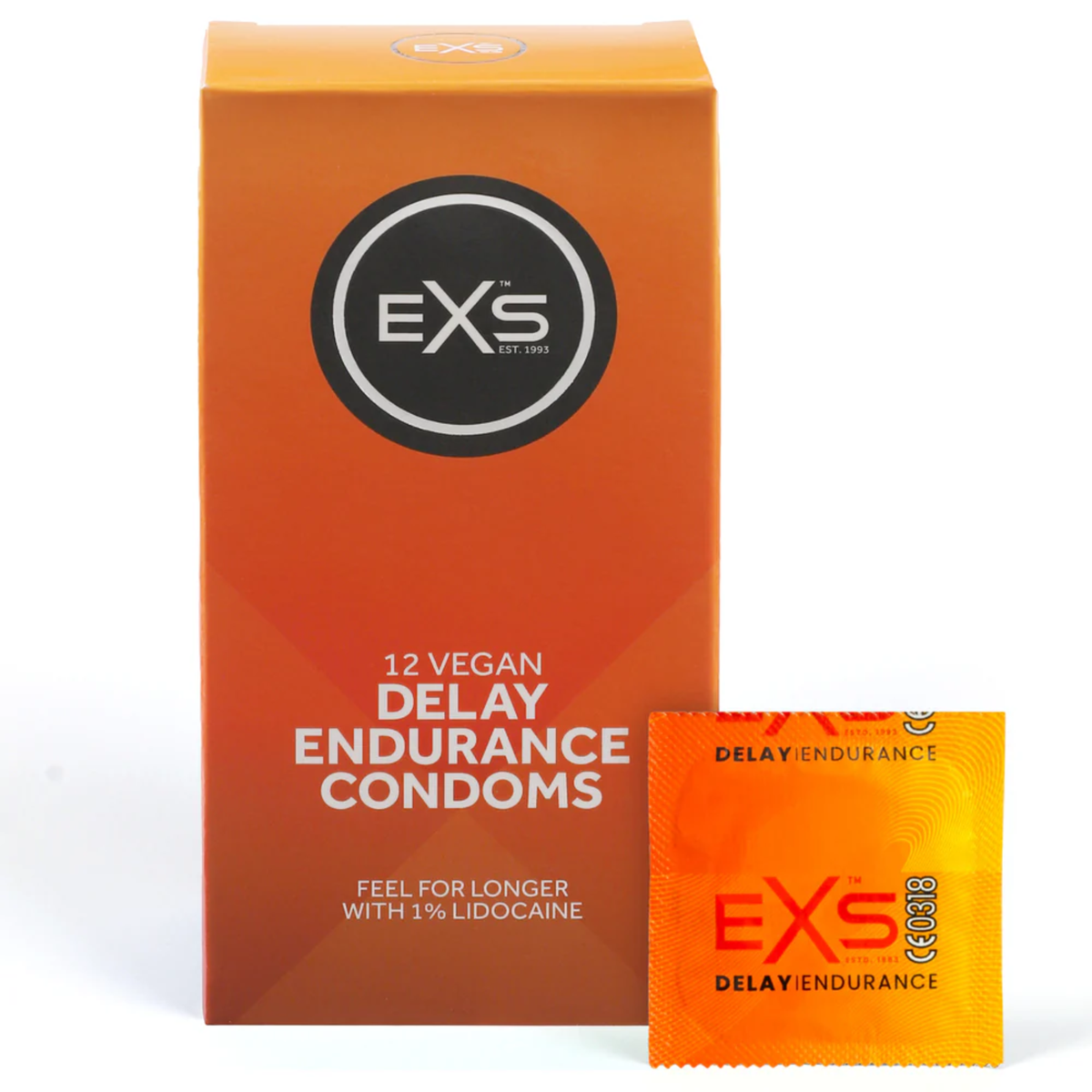 Studio product shot showing the orange box of EXS 12 Vegan Delay Endurance Condoms standing next to a single sealed orange foil wrapper against a white background. Main image