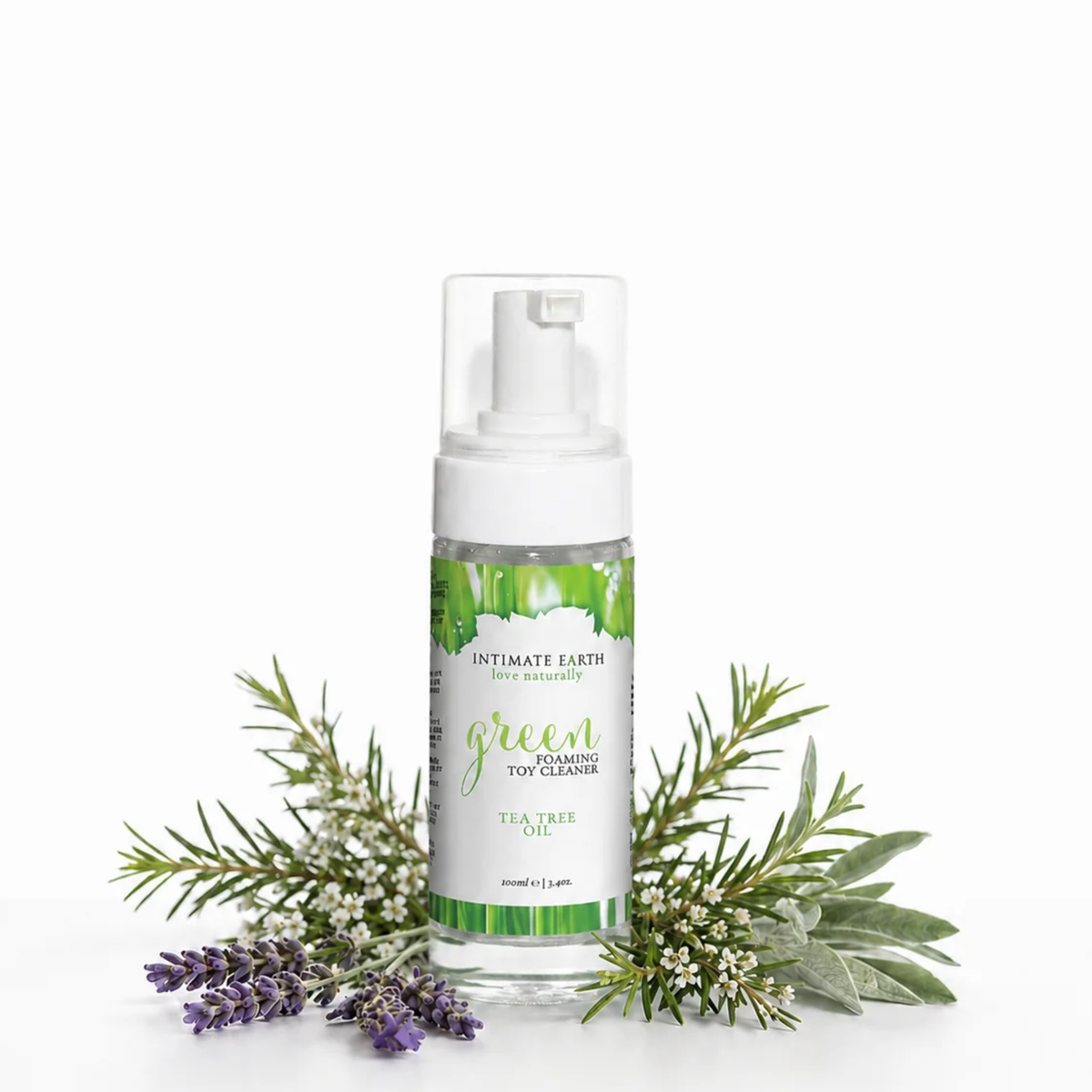 Nature-inspired lifestyle photo showing the 100 ml Intimate Earth Green foaming toy cleaner bottle surrounded by fresh lavender sprigs and tea tree leaves.