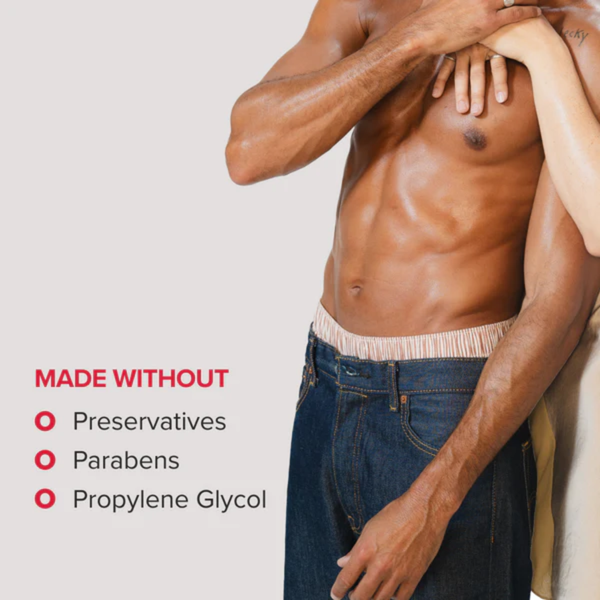 A cropped image of a fit, shirtless man in jeans with a partner's hand resting on his chest. Red bullet points on the left indicate that the product is "MADE WITHOUT" preservatives, parabens, or propylene glycol.