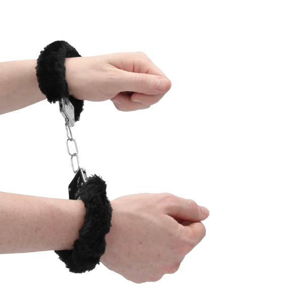 Pair of hands wearing the Ouch! Beginner's Furry Handcuffs Black.