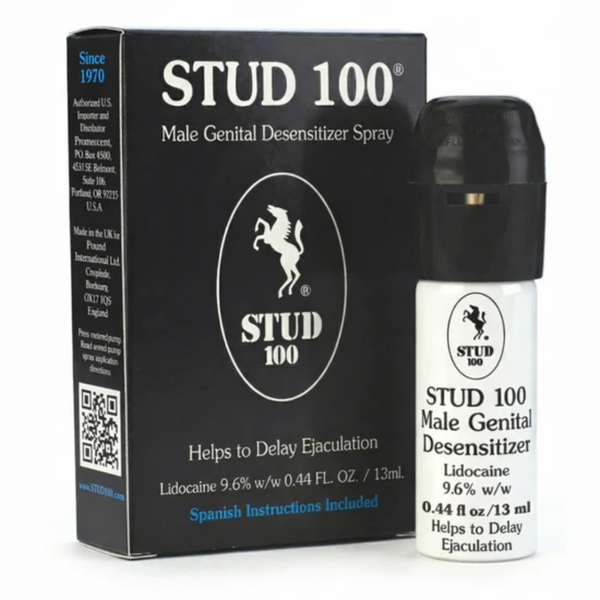 A black retail box and a small white spray bottle of STUD 100 Male Genital Desensitizer Spray. The packaging features a white stallion logo and highlights that the formula contains Lidocaine 9.6% w/w. The text notes it "Helps to Delay Ejaculation" and includes Spanish instructions.
