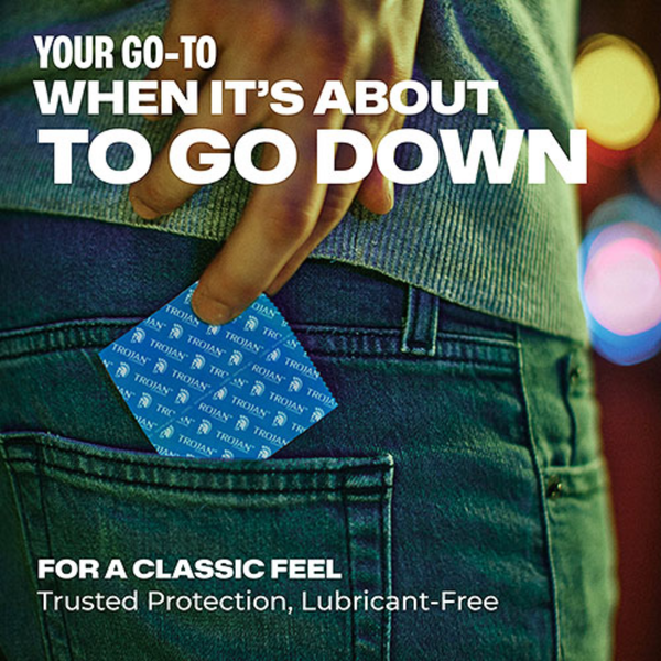 A lifestyle shot of a person’s hand reaching into their denim back pocket to pull out a blue Trojan foil condom wrapper. The text reads: "YOUR GO-TO WHEN IT'S ABOUT TO GO DOWN."