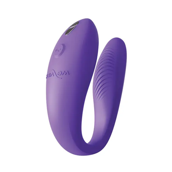 Angled studio view of the light purple We-Vibe Sync Go massager highlighting its control button, embossed logo, and silver charging contacts.